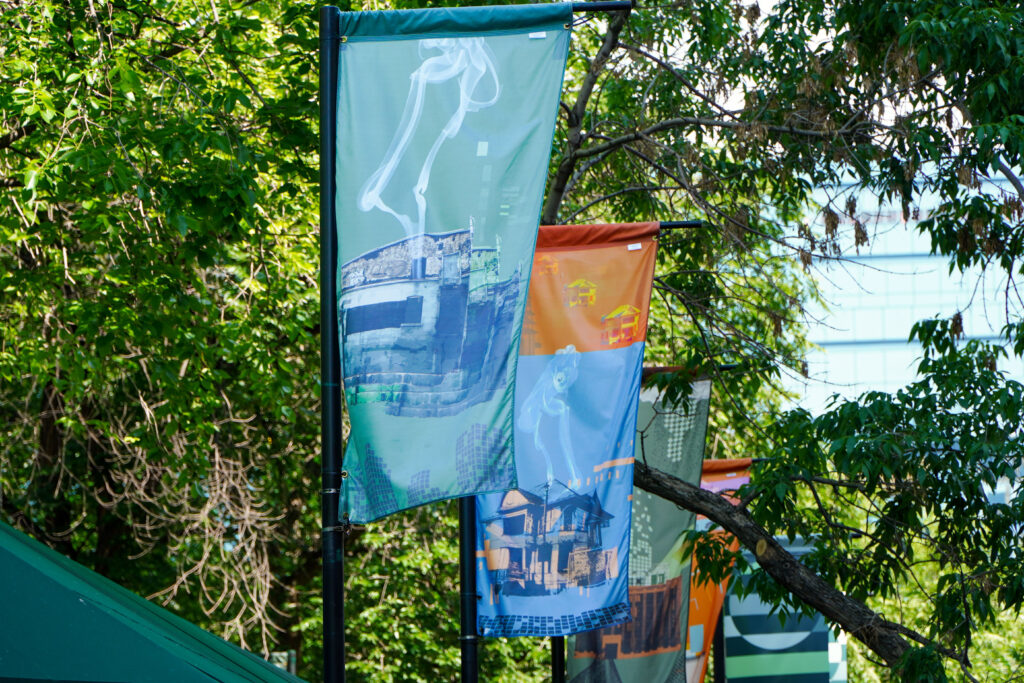 Banners featuring artworks by Słavek Pytraczyk hang on posts in Calgary's downtown.