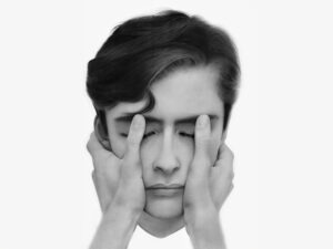 A black-and-white hyperrealist drawing of a person whose face in being held in someones hands, by Alexander Akhere Oriaifo