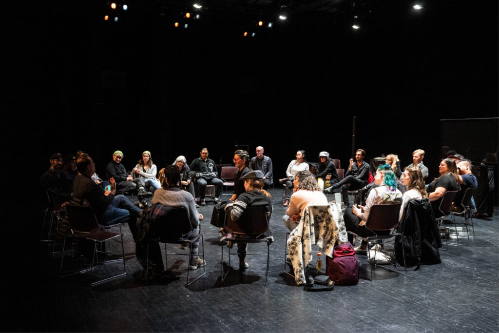 A group of playwrights gathered in a circle conversing together for the Playwrights Lab by Banff Centre.