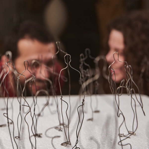 Artist collective  Incipio Modo in soft focus behind a wire artwork.