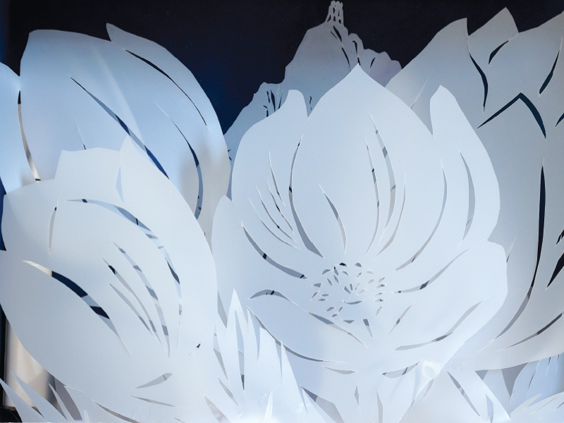 Foil cut artwork by Marketa Praskova, white paper cutouts of flowers layered together. 

