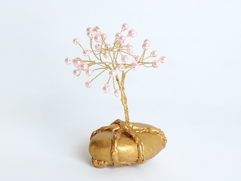 Mixed media sculpture by Saloni Sharma of miniature tree sculpture with a gold base and branches with pink pearls as leaves.