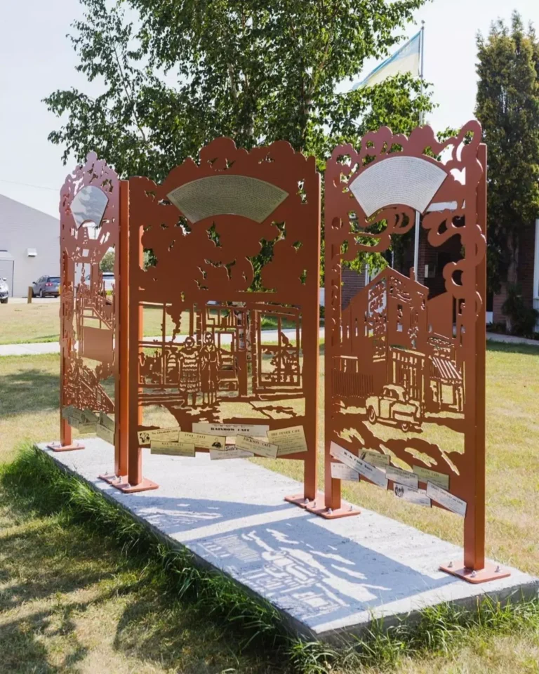 Outdoor metal installation with cut-out scenes of street life.