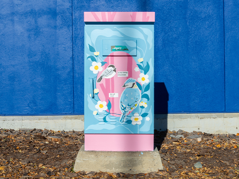 A utility box painted with colourful birds and flowers.