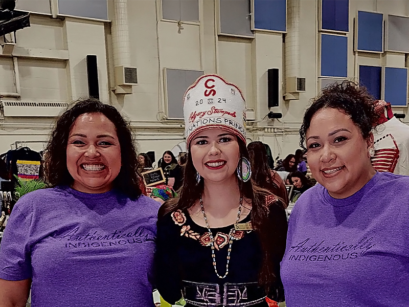 Three Indigenous women standing in a market setting