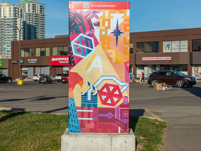 A utility box in a parking lot, painted with colourful shapes and abstract designs.