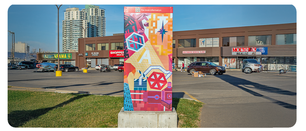 A utility box in a parking lot, painted with colourful shapes and abstract designs.