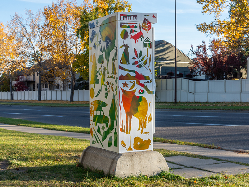 A utility box painted with colourful wildlife silhouettes.