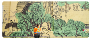 Large mural by Rawry & Pohly featuring Bianjing Gate to the City, green trees and pathways on a pale yellow background, and a person in an orange safety vest staring at the mural.