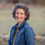 Geraldine Ysselstein smiling wearing a denim jacket standing outdoors