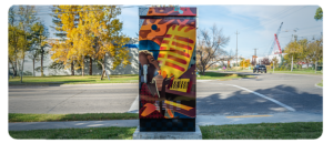 A utility box painted with a colourful design of a person singing into a microphone.