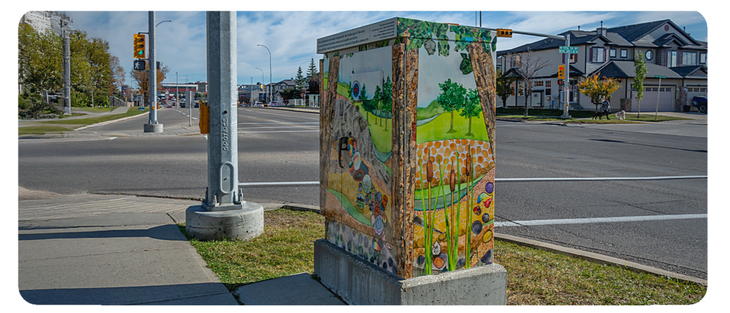 A utility box painted with a nature-inspired mural featuring trees, plants, rocks, and a scenic landscape.