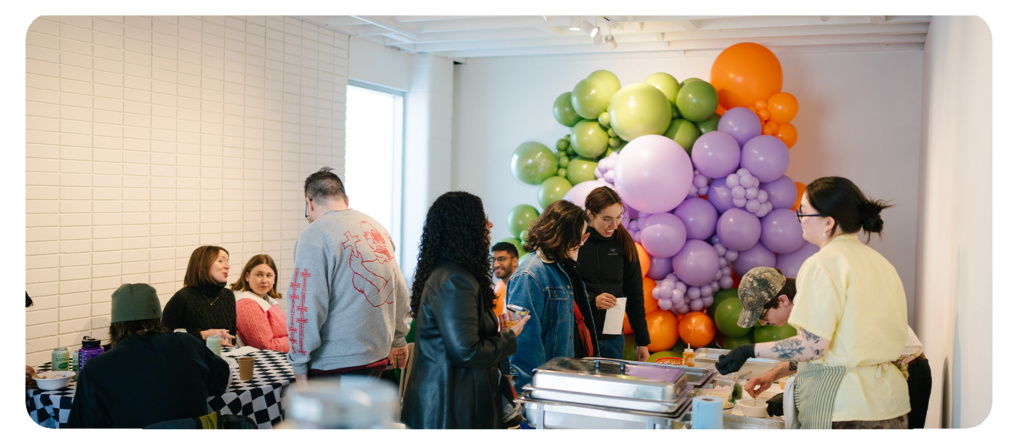 People socializing in a room with colourful balloon.