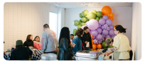 People socializing in a room with colourful balloon.