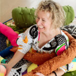 Yvonne Mullock sitting amongst stuffed fabric arms smiling