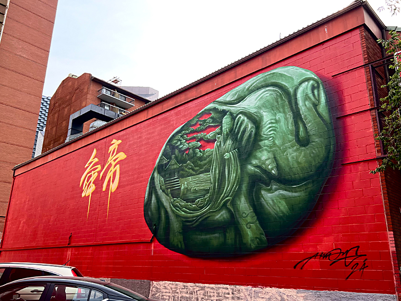 A red and greet wall mural by Alex Kwong