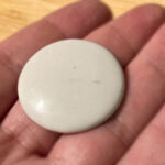 A hand holding a smooth Snake eye stone