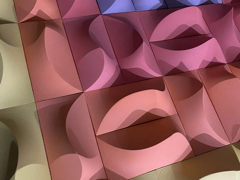 Artwork that looks like raised geometrical shapes in blue, pink, rose and gold colour
