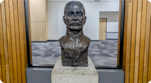 Colonel McLeod bronze bust, sculpture about 3' high, situated in front of wood paneling