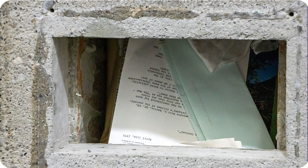 The time capsule open with documents and letters showing at the top