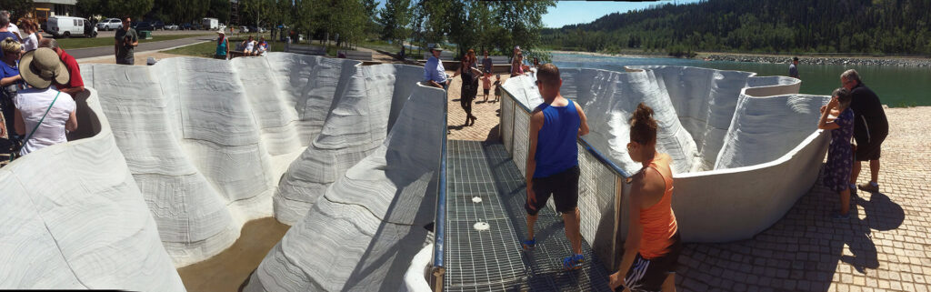 Wavy forms by the Bow River with people standing discussing them | Outflow Glacier by Brian Tolle