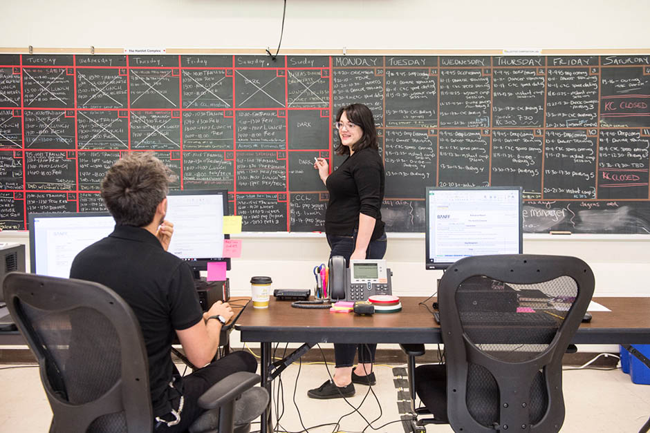 Students working in a classroom with a chalkboard and full of writing and ideas