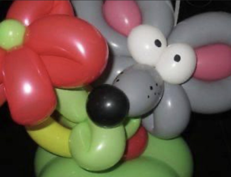Some examples of balloon twisting. It looks like a rat or mouse and another which is a flower with a green stem and red bloom.