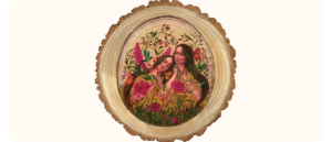 A circular painting on a wood slice featuring two women surrounded by vibrant pink flowers, butterflies, and birds. The women have calm expressions, eyes closed and are nestled closely together.