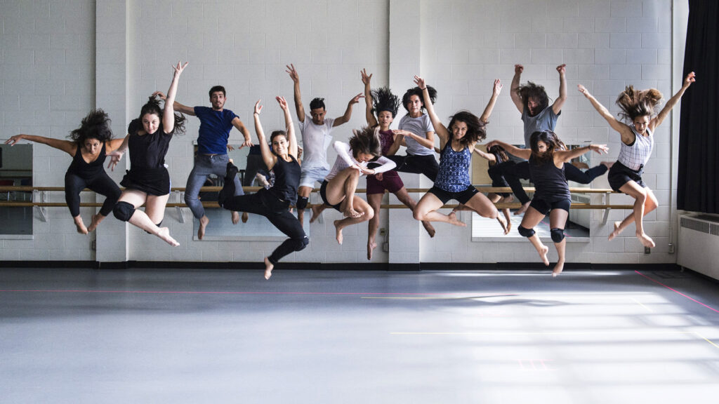 Dancers of various backgrounds and genders, leap in the air and are captured mid-leap with different poses.