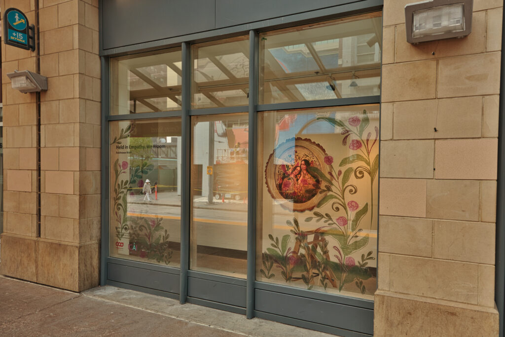Artworks presented behind a window on the Centre Street LRT platform and vinyl over the top of the glass. The artworks are by artist Bukhtawar Malik .
