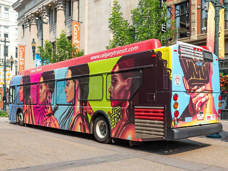 A Calgary Transit bus covered in artwork for the Public Art, Art Bus program. Artwork by Sydonne Warren