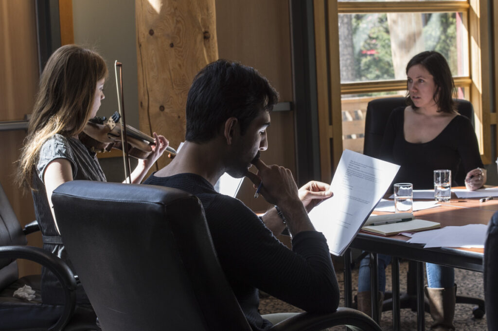 Musicians and other artists gather around a table as they work on a project in a studio at the Banff Centre.