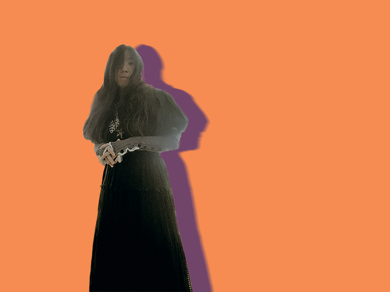 Portrait photo of Kara Mains in front of an orange background.