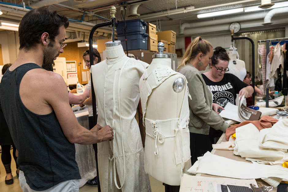 Students and artists looking at patterns on bust forms in a costuming department setting
