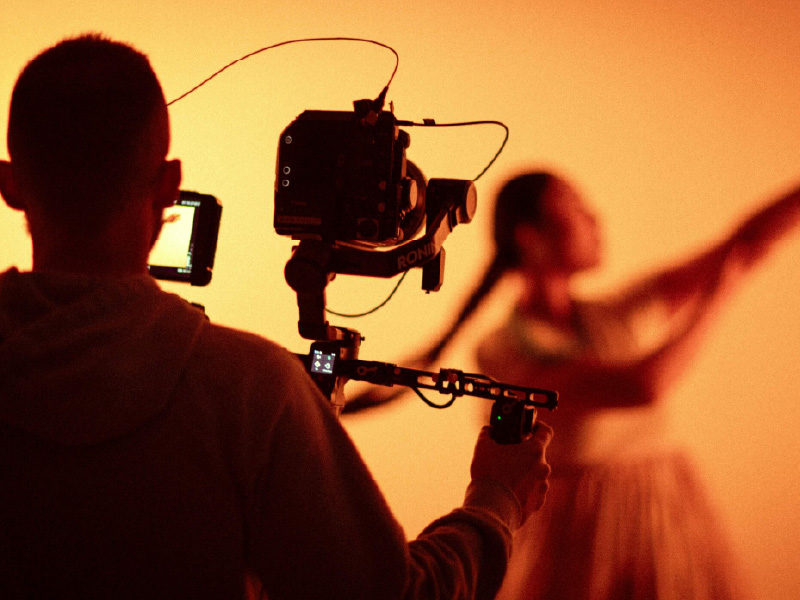 Camerman shoots video of woman who is not in focus mid-movement, likely a dance.